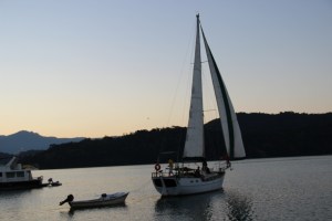 Alex saindo para velejar ao cair da tarde, com seus convidados. Olha a quantidade de botes amarrados na popa. E o Alexandre, do Trawler Maiô, entrando no seu inflável para juntar-se à turma.