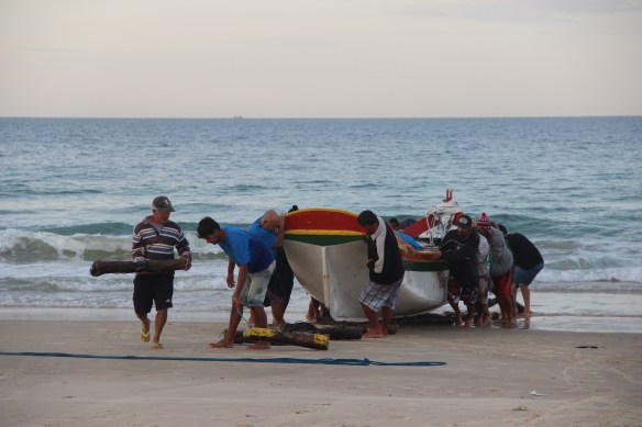 À moda antiga - rolando a canoa sobre toras de madeira para coloca-la no seco.