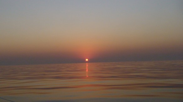 Pôr do sol em alto mar num dia/noite sem qualquer vento.